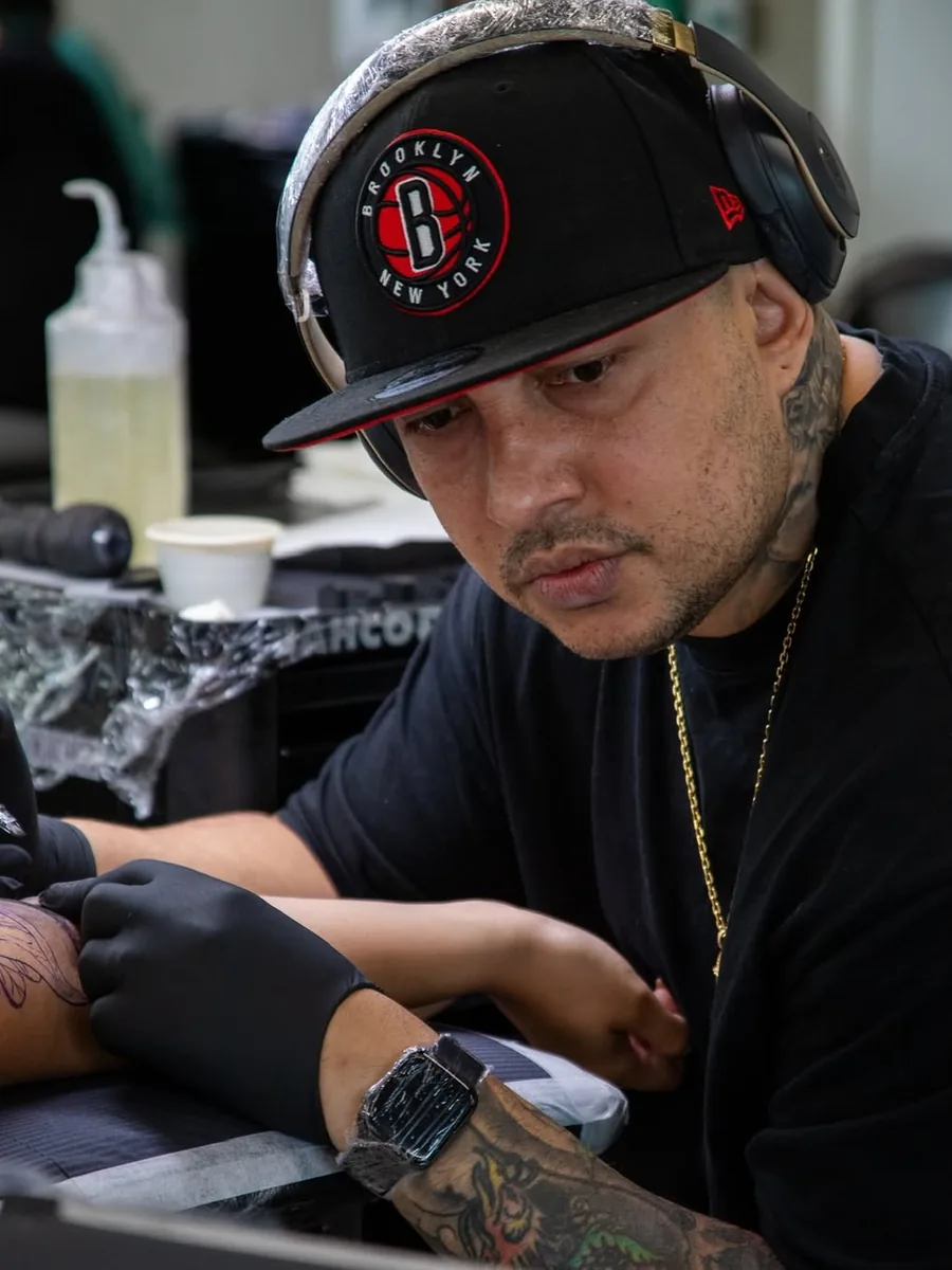 Victor Armero tattooing a client in the studio