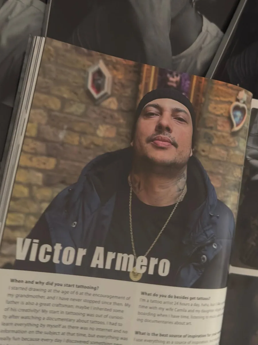 A tattoo magazine open at a feature interview with Victor Armero