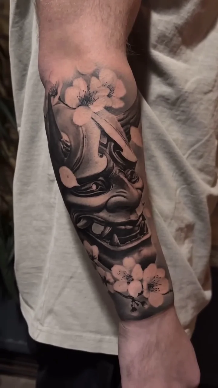 a Hannya mask among blossom, wrapping the arm, STYLE tattoo by ARTIST NAME, NEIGHBOURHOOD CITY
