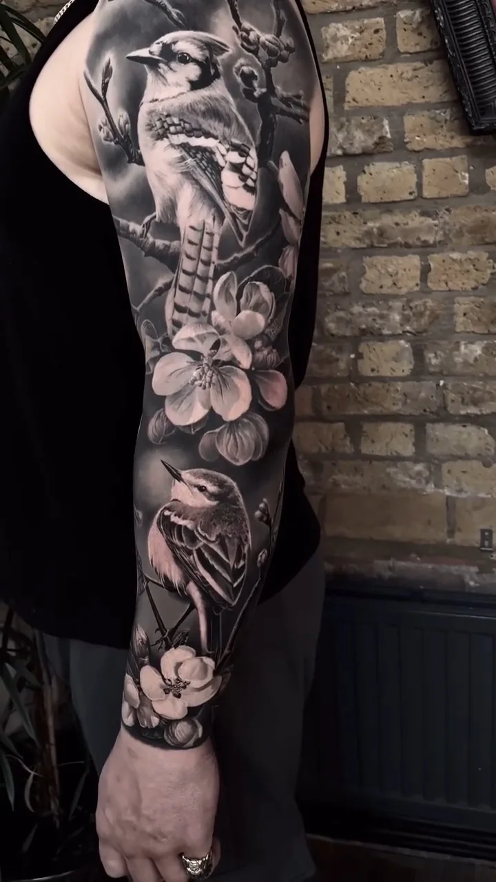a bird among cherry blossom, running the length of the sleeve, black and grey realism tattoo by Victor Armero, Plymouth