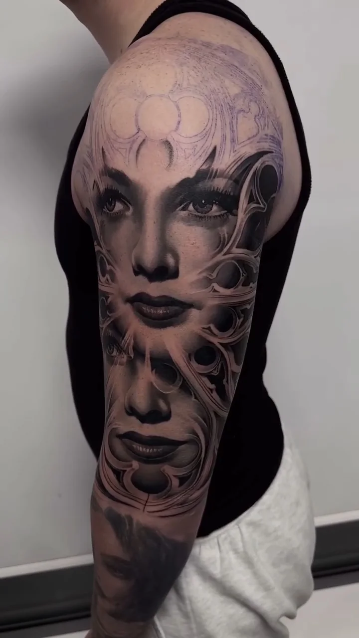 a woman's face filling the sleeve, cut through with abstract panels, STYLE tattoo by ARTIST NAME, NEIGHBOURHOOD CITY